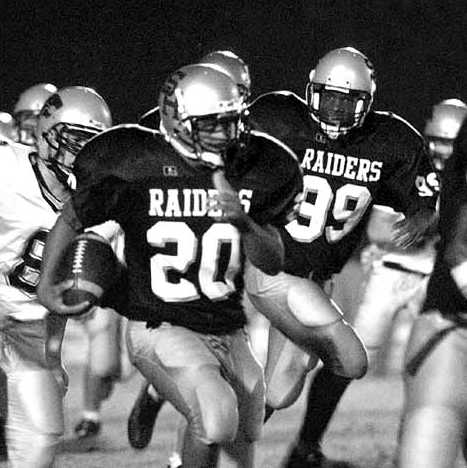 Chris Smith (20) races for extra yardage while receiving an escort from teammates