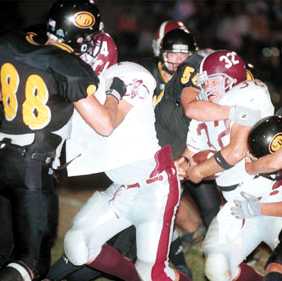 Neal Ricker struggles for yardage as Jason Johnson (55) wraps him up
