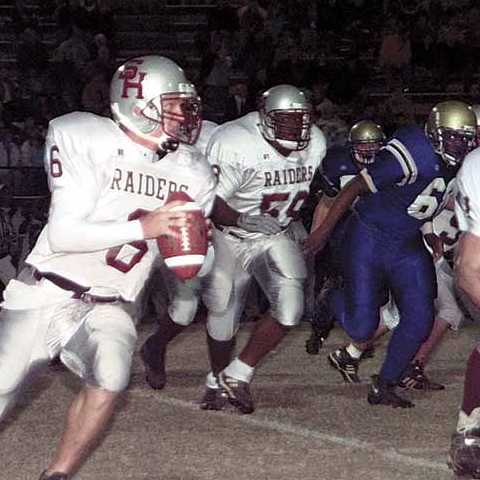 Spring Hill quarterback Jason Hoath cuts around to the right side of the field as Samuel Ridley (59) attempts to help block.