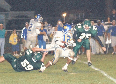 Rockwood's Zach Scruggs holds on to Jam Ferguson as Josh Clark closes in.