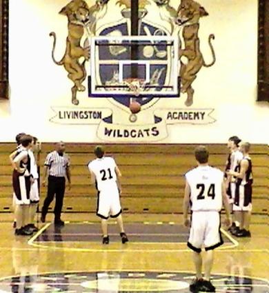 Clay County's #21 Freshman Jacob Smith hits a foul shot, and #24 sophomoreJustin Spivey looks on.