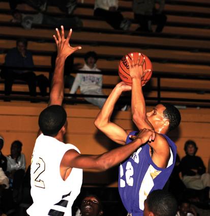 Kenneth Gumbel shots a jumper over Millington's Larry Green.