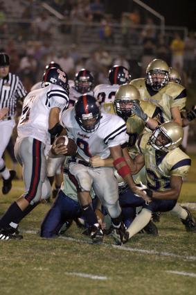 Creek Wood's Josh Vaughn (9) is brought down by lead Sycamore tackler Maurice Polk (31) and two other War Eagles.