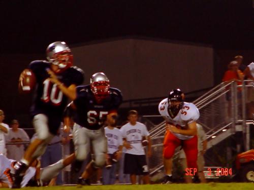 #10 Addison scrambles as #65 Tyler Pratt adds the protection