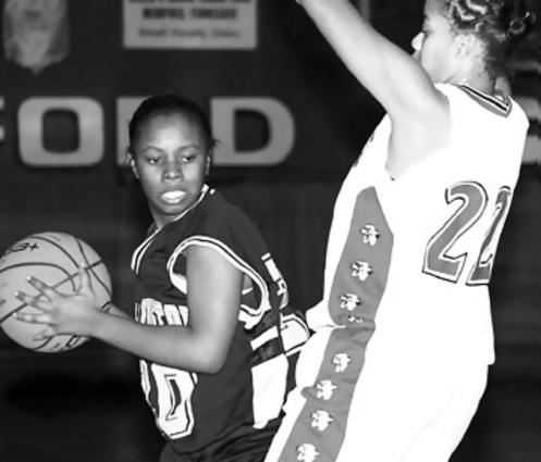 Millington's Gloria Scott look to pass from the defense of Munford's Whitney Malone.