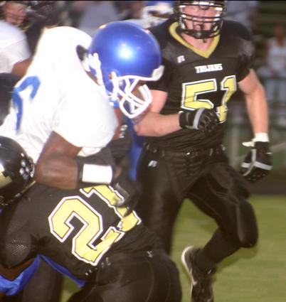 Trojan Derron Harwell puts a stop to a Wolverine runner.