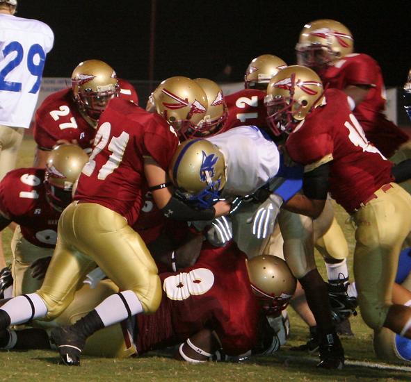 A Wilson Central ball carrier finds himself stuck in a mountain of Riverdale Warrior  