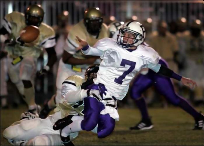 Portland quarterback Colton Williamson (7) hands off the ball before being tackled by Springfield's (44) Travis Chatman.