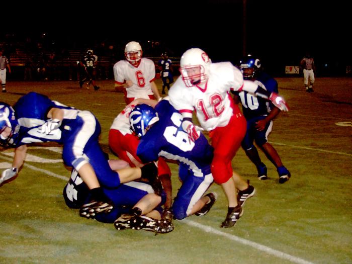 #63 Michael Runion works hard to make a tackle as his teammated provide needed support.